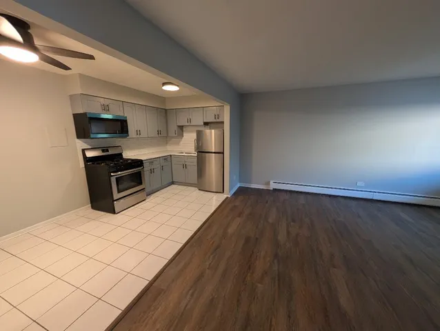 a kitchen with a refrigerator and a stove top oven