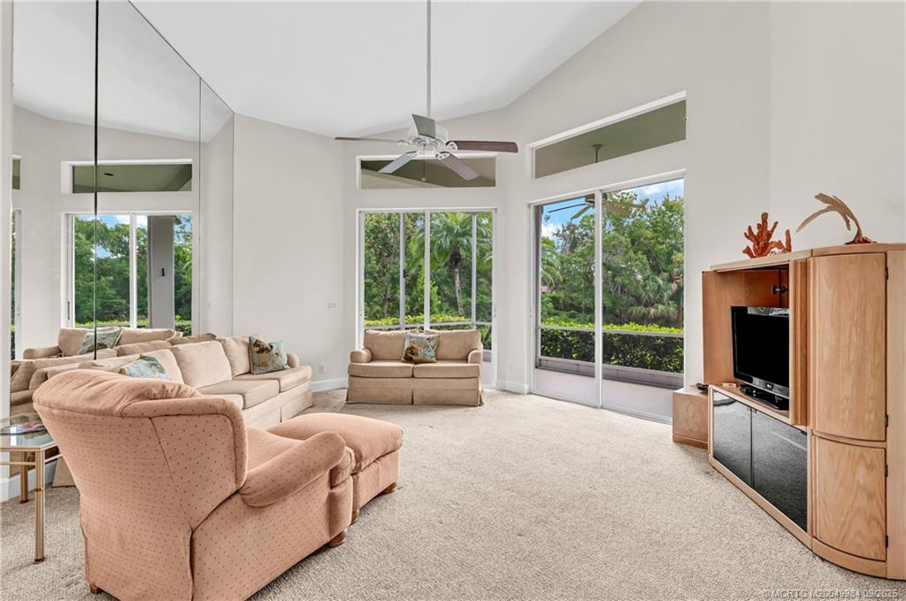 13005 Harbour Ridge Boulevard Palm City, FL 34990 - Photo 12 of 40 a living room with furniture a flat screen tv and a large window