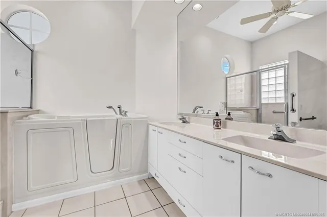 a bathroom with a double vanity sink toilet mirror and shower