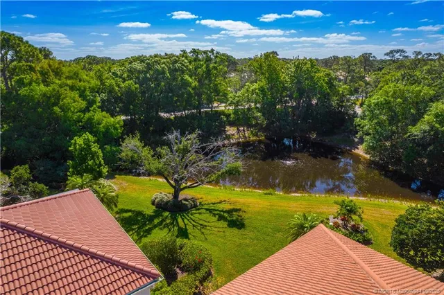 an aerial view of residential houses with outdoor space and trees