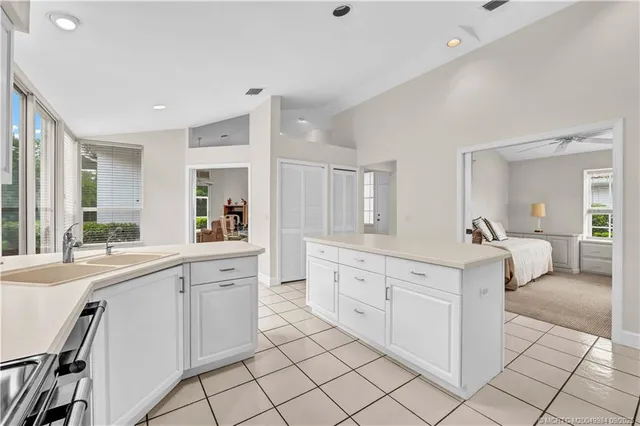 a large white kitchen with cabinets and chairs