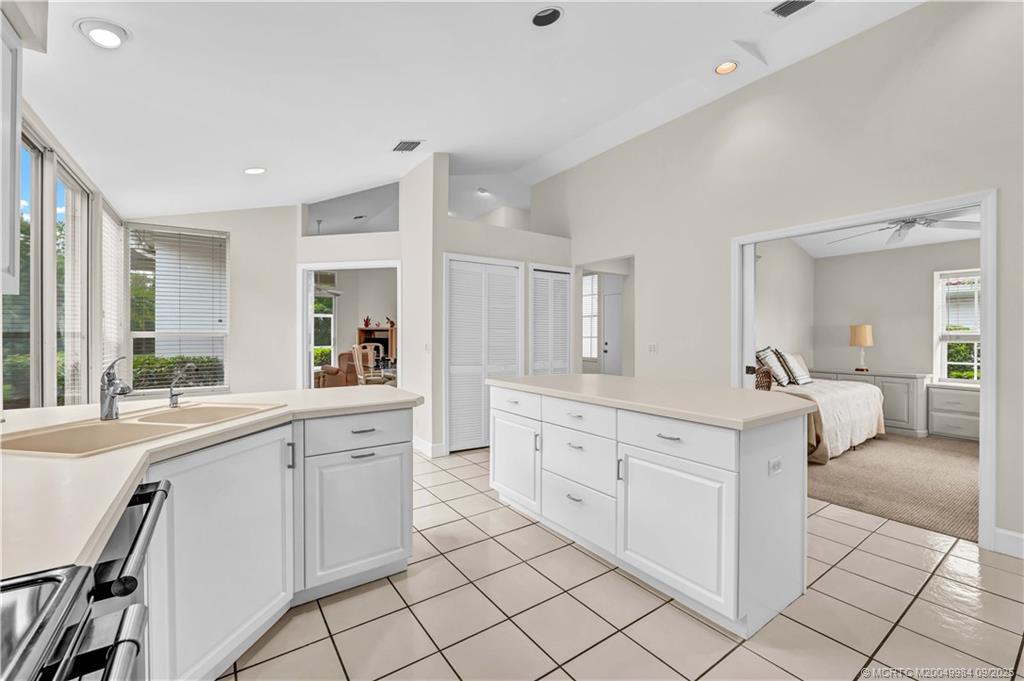 13005 Harbour Ridge Boulevard Palm City, FL 34990 - Photo 4 of 40 a large white kitchen with cabinets and chairs