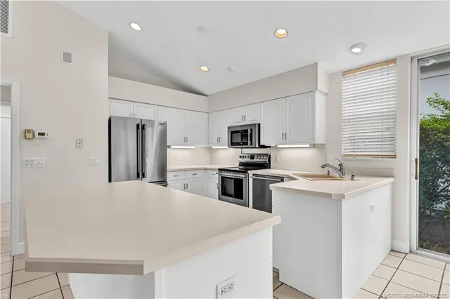 a kitchen with stainless steel appliances a sink stove refrigerator and cabinets