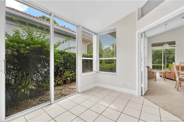 a dining room with furniture and large windows