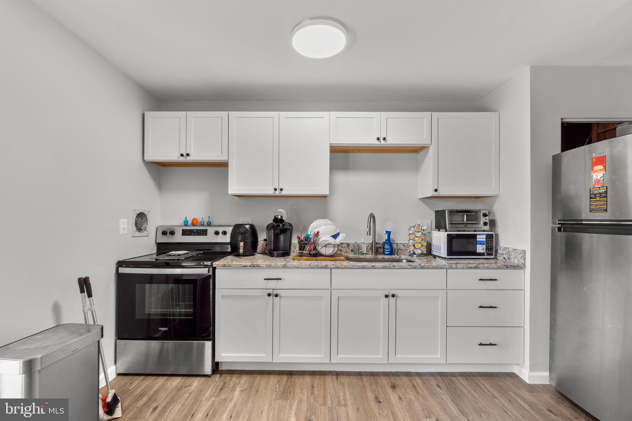 313 Janice Way Westminster, MD 21158 - Photo 7 of 23 a kitchen with white cabinets and sink