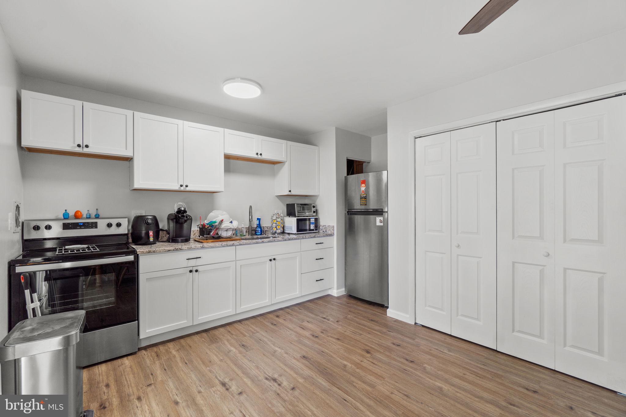 313 Janice Way Westminster, MD 21158 - Photo 8 of 23 a kitchen with stainless steel appliances white cabinets and wooden floors