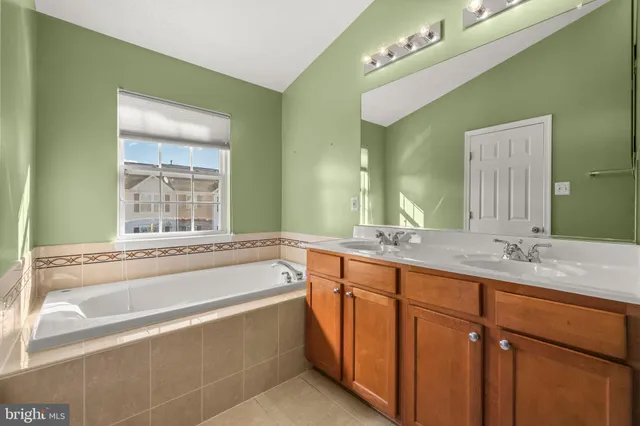 a spacious bathroom with a granite countertop tub sink and mirror