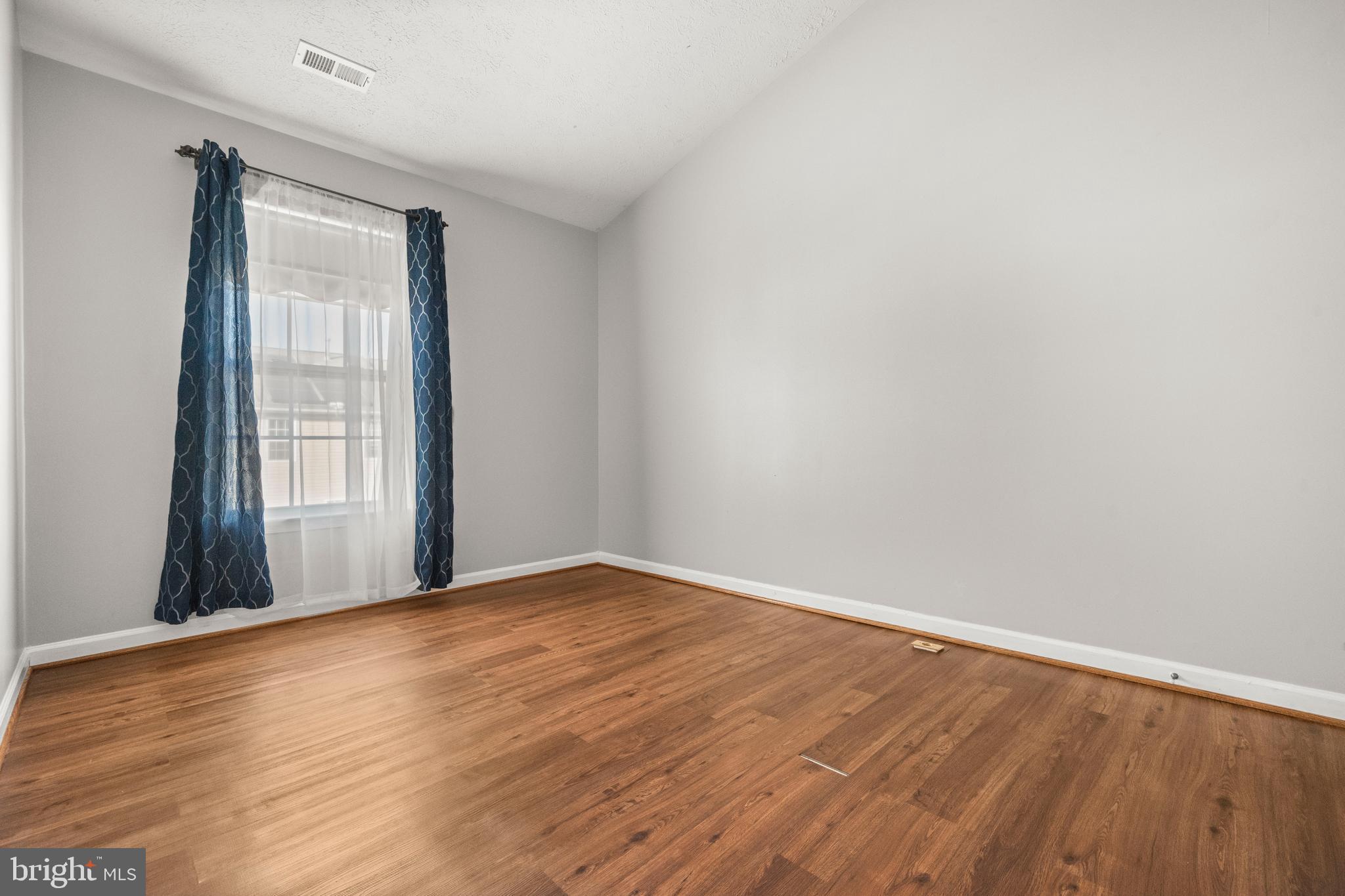 826 Lowe Road Baltimore, MD 21220 - Photo 17 of 35 a view of an empty room with wooden floor and a window