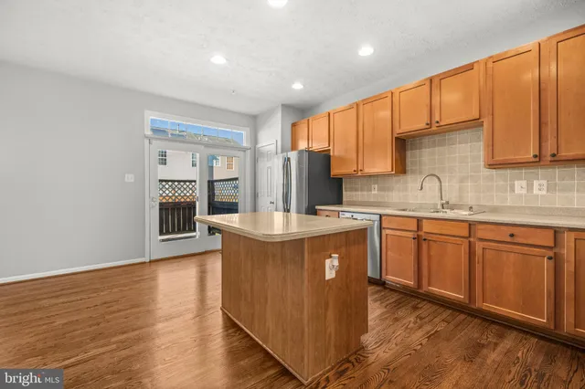 a kitchen with stainless steel appliances granite countertop a sink stove and wooden cabinets