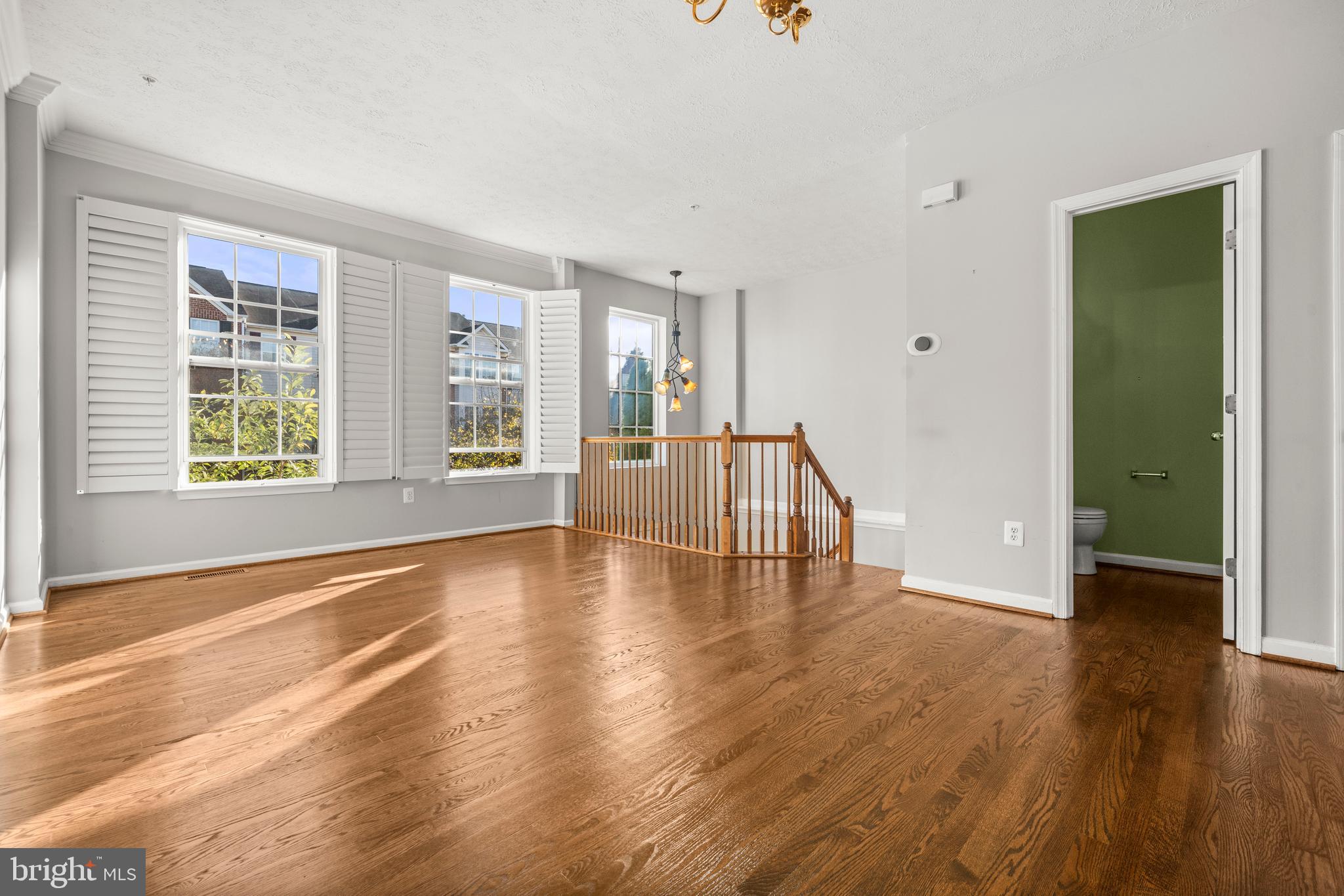 826 Lowe Road Baltimore, MD 21220 - Photo 9 of 35 an empty room with wooden floor and windows