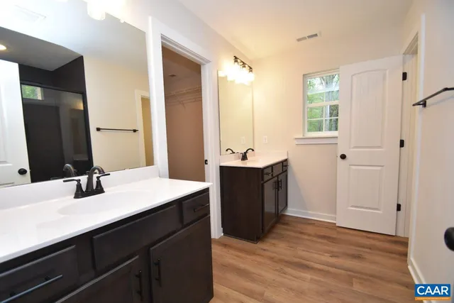 a bathroom with a sink double vanity granite tub shower and a mirror