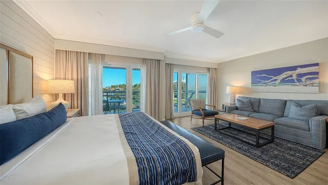 a spacious bedroom with a bed a couch and large window