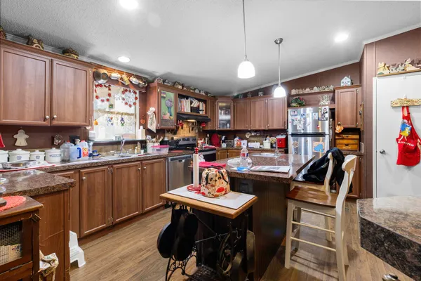 a kitchen with kitchen island granite countertop a sink cabinets and wooden floor