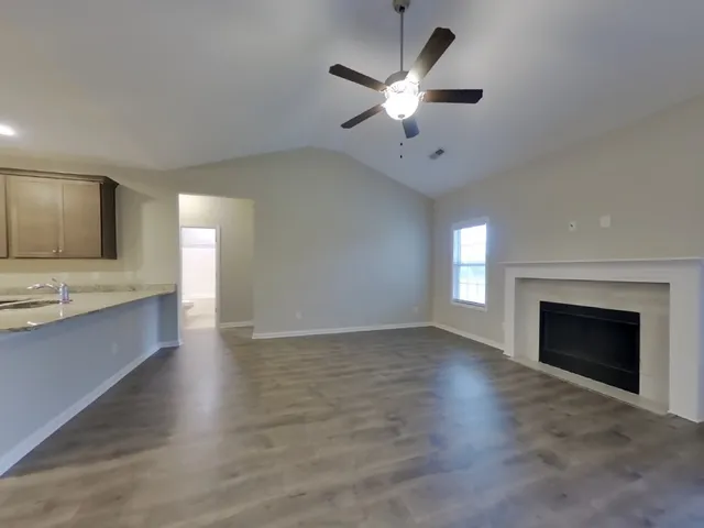 an empty room with a fireplace and sink