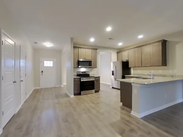 a kitchen with stainless steel appliances kitchen island granite countertop a stove and a sink