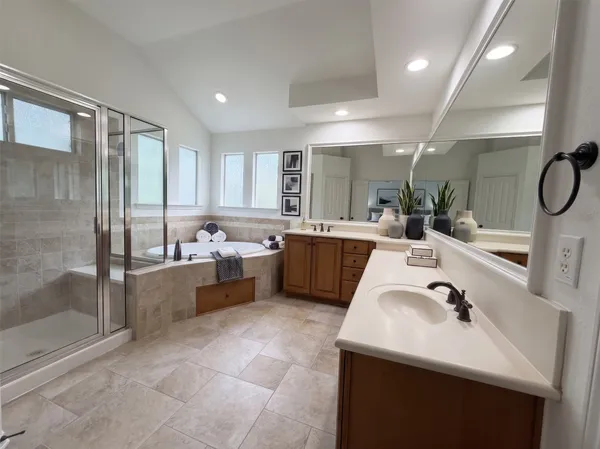 a large white bathroom with a double vanity sink a mirror and a shower