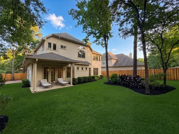 a view of a house with garden and a tree
