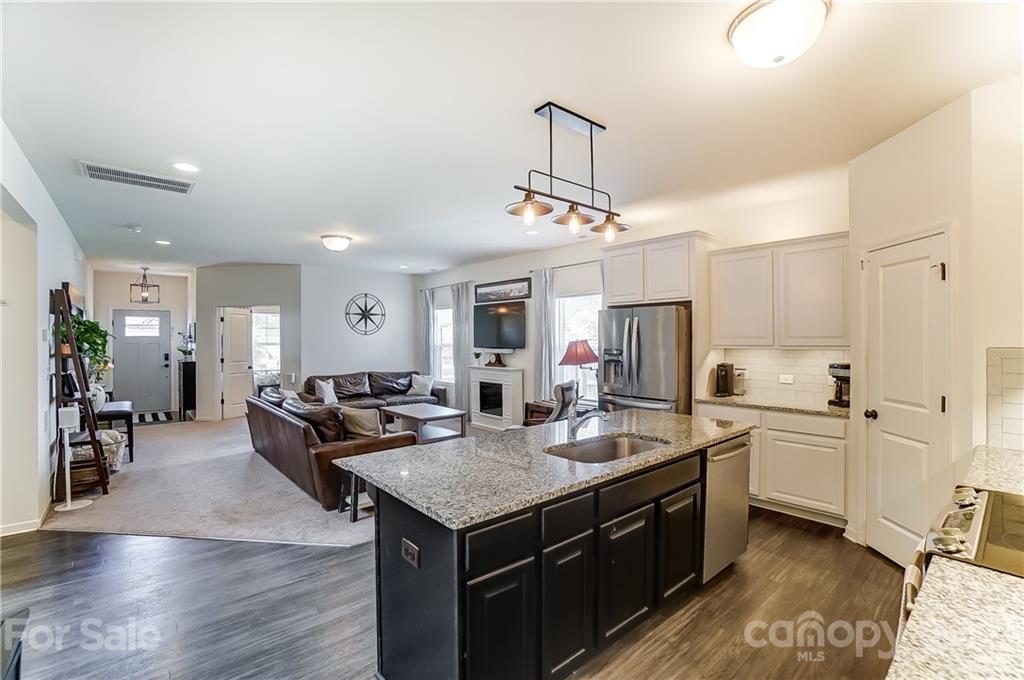 3047 Riker Street Clover, SC 29710 - Photo 14 of 33 a open kitchen with stainless steel appliances granite countertop a sink dishwasher and a stove with wooden floor