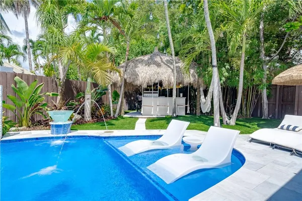 a view of a house with backyard water fountain and sitting area