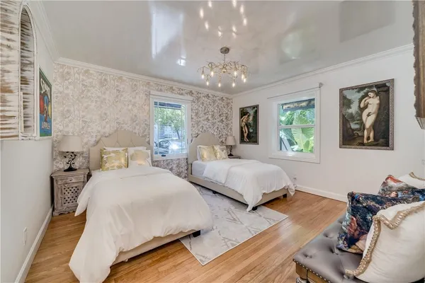 a bedroom with a large bed and a chandelier