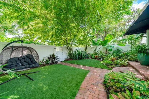 a view of a backyard with garden and patio