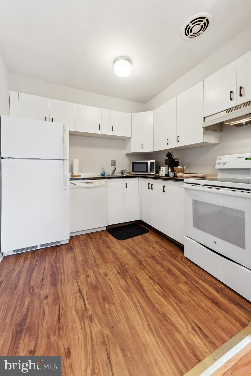 1334 Montgomery Avenue, Unit D3 Narberth, PA 19072 - Photo 7 of 15 a kitchen with wooden floors and white appliances