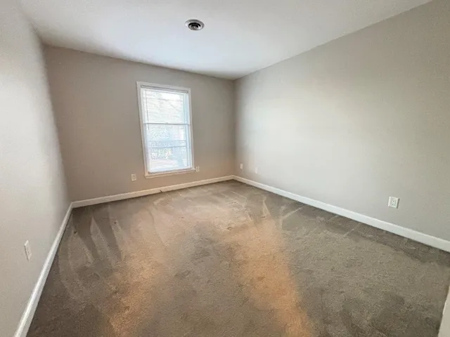 an empty room with closet and a window