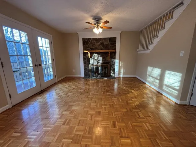a view of an empty room with fireplace and a window