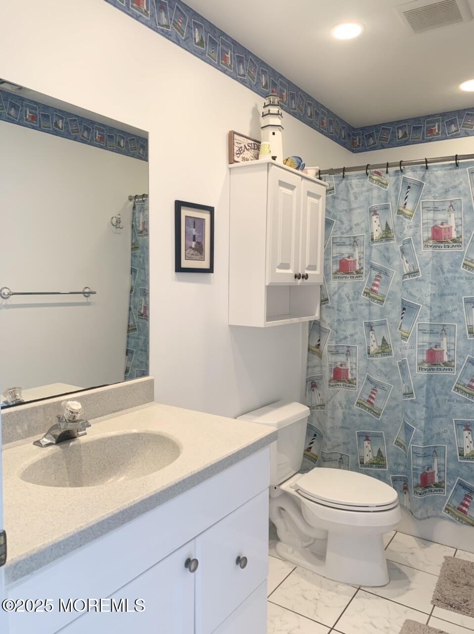 15 9th Avenue, Unit UPPR Seaside Park, NJ 08752 - Photo 16 of 24 a bathroom with a sink a toilet and shower curtain