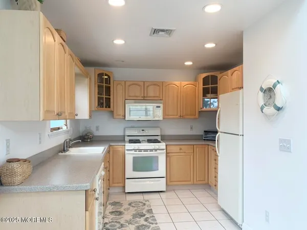 a kitchen with a sink a stove a refrigerator and cabinets