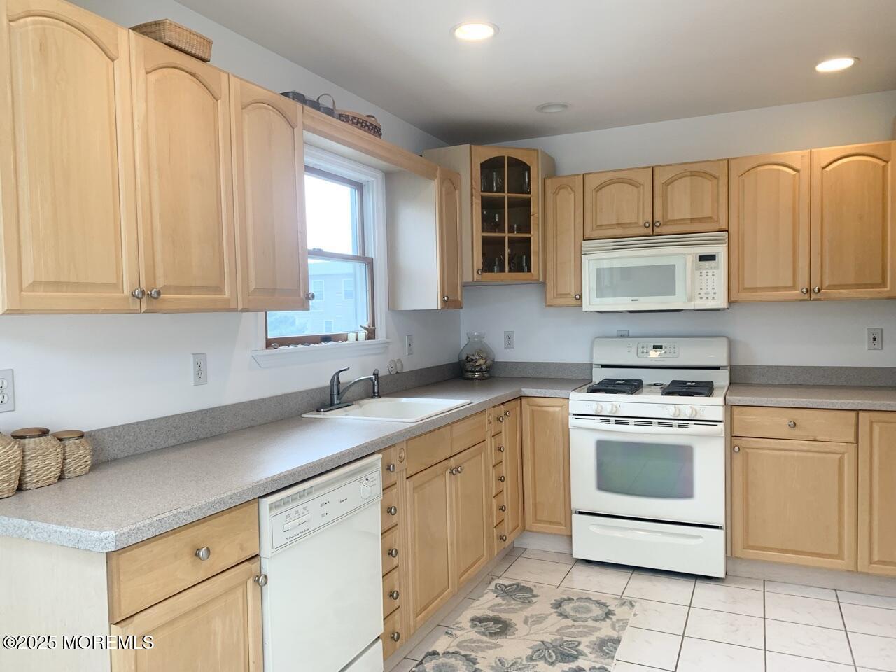15 9th Avenue, Unit UPPR Seaside Park, NJ 08752 - Photo 8 of 24 a kitchen with granite countertop white cabinets stainless steel appliances a sink and a window