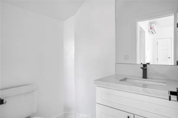 a bathroom with a granite countertop bathtub shower sink vanity and toilet