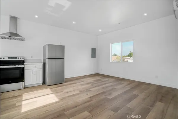 a kitchen with granite countertop a sink stainless steel appliances and window