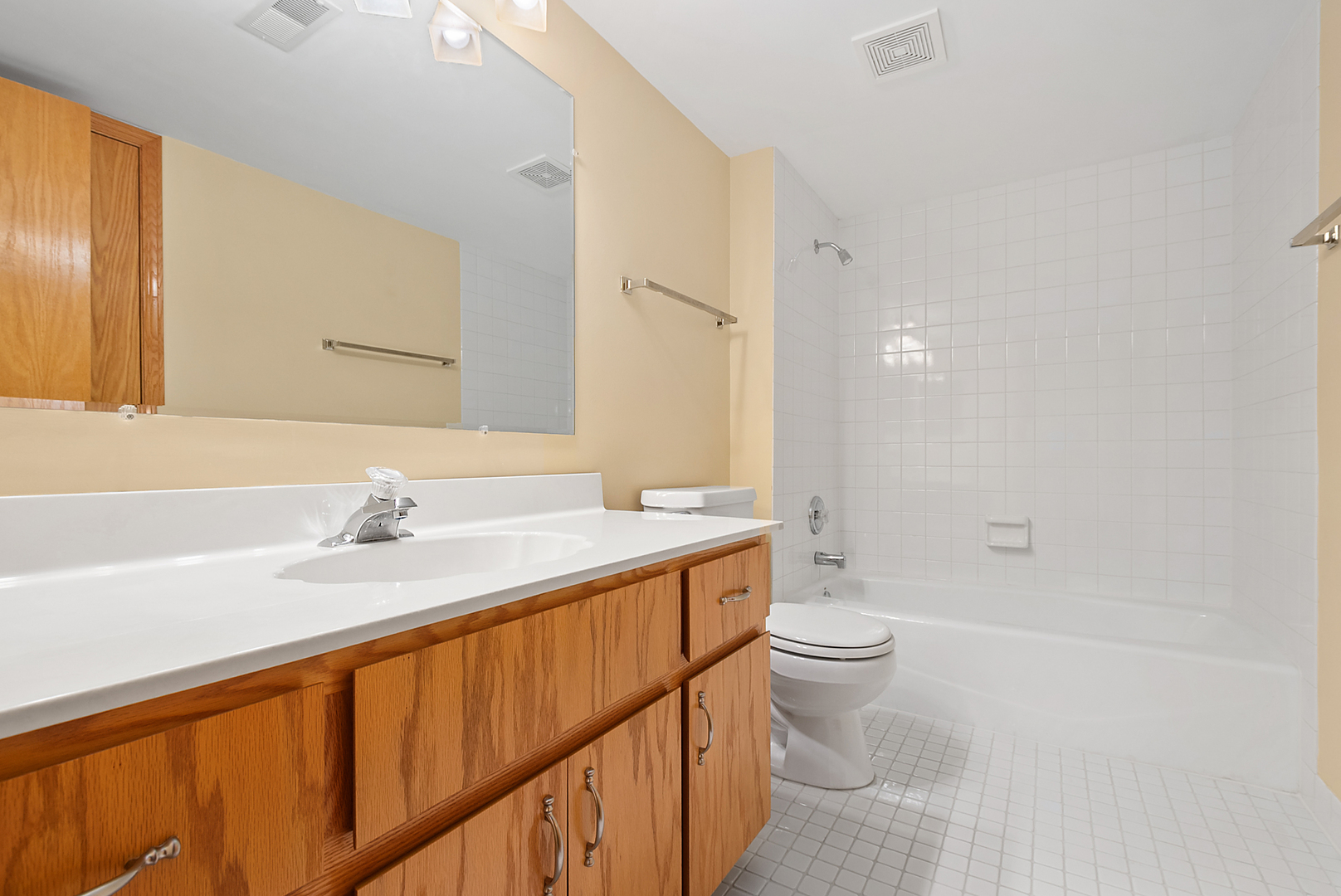 7811 West 157th Street, Unit 1N Orland Park, IL 60462 - Photo 15 of 18 a bathroom with a granite countertop sink a toilet and a large mirror