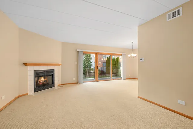 a view of an empty room with a fireplace and a window