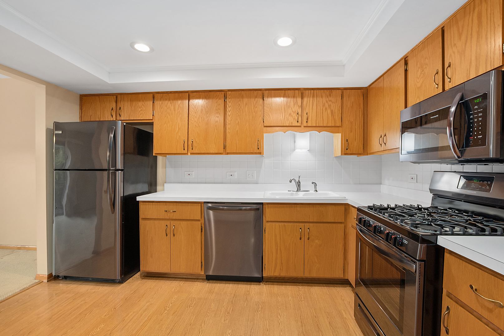 7811 West 157th Street, Unit 1N Orland Park, IL 60462 - Photo 9 of 18 a kitchen with stainless steel appliances granite countertop a refrigerator stove and a sink