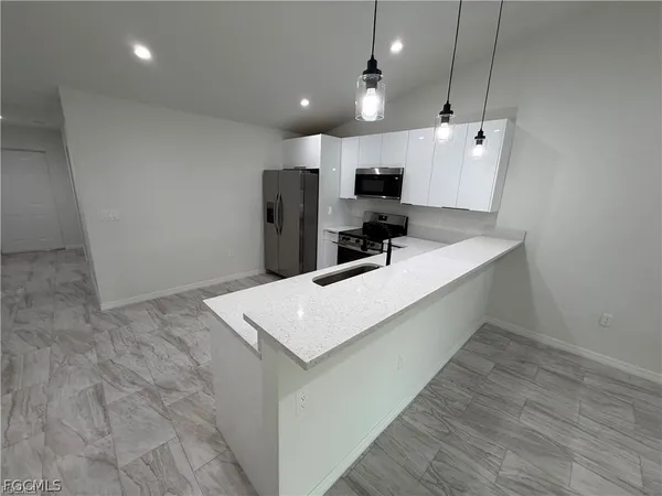 a view of a kitchen with a sink and a refrigerator