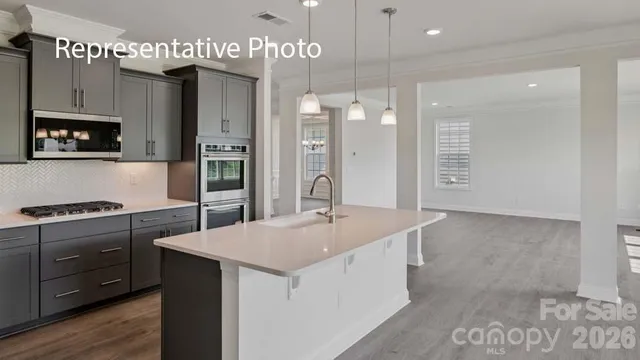 a kitchen with stainless steel appliances granite countertop a sink a stove and a refrigerator