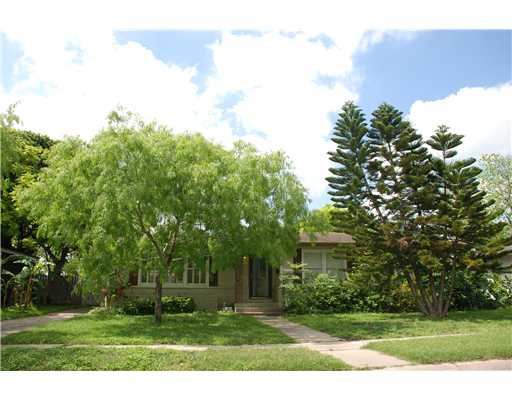 a backyard of a house with plants and large trees