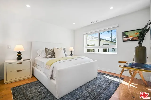 a bedroom with a bed and a computer on desk