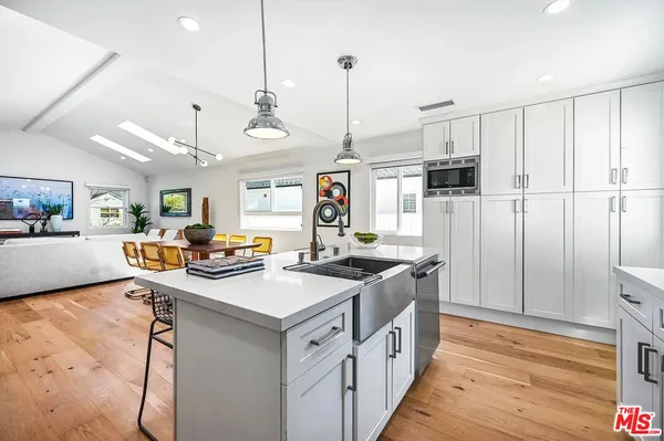 a kitchen with stainless steel appliances granite countertop a sink a stove and a refrigerator
