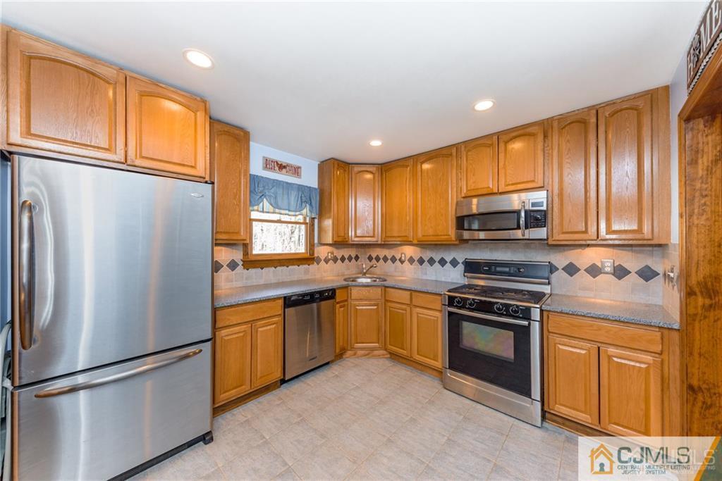 204 Amboy Road Old Bridge, NJ 07747 - Photo 8 of 25 a kitchen with stainless steel appliances granite countertop a refrigerator stove top oven and sink