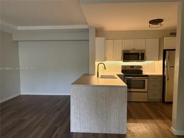 a kitchen with kitchen island a sink counter top space and stainless steel appliances