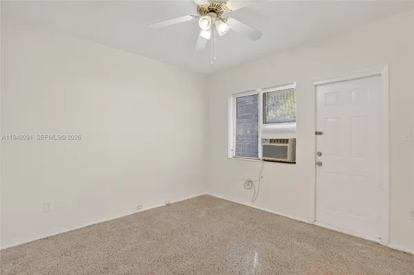 an empty room with windows and fan