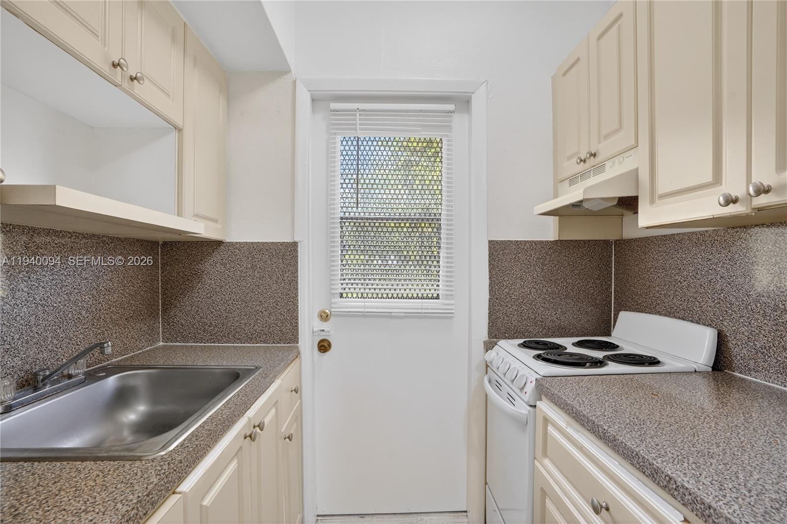 140 Southwest 30th Court, Unit 130 Miami, FL 33135 - Photo 10 of 18 a kitchen with granite countertop a sink stove and cabinets