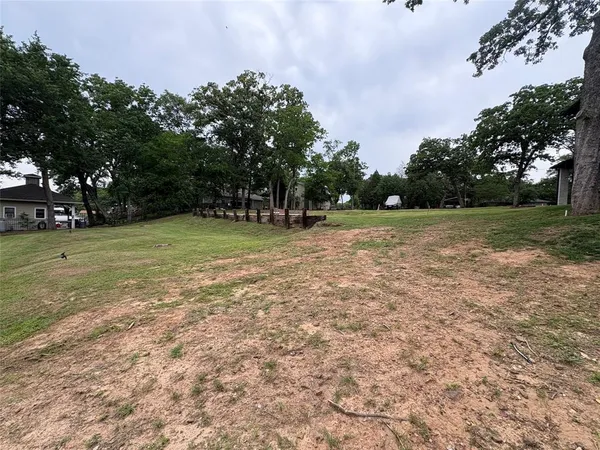 a view of a field with trees in the background