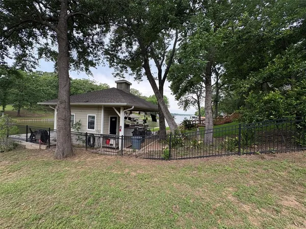 a view of a house with a backyard and a tree