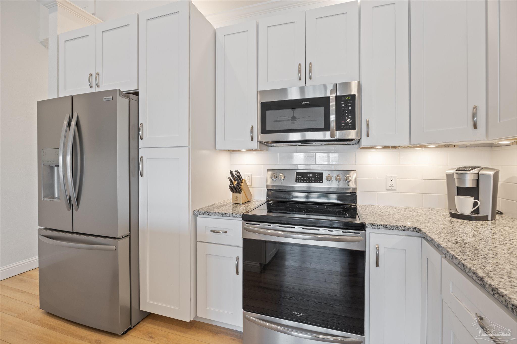 17290 Perdido Key Drive, Unit B2 Pensacola, FL 32507 - Photo 15 of 54 a kitchen with stainless steel appliances white cabinets and a granite counter tops
