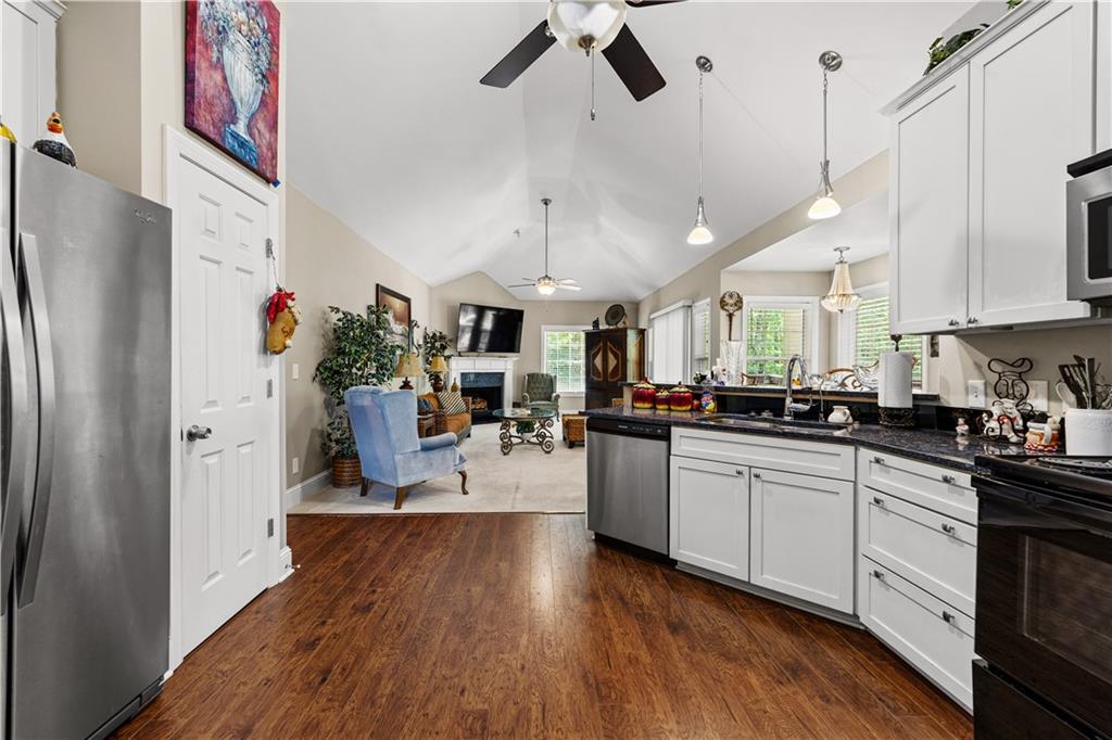 915 Magnolia Way Hampton, GA 30228 - Photo 22 of 68 a kitchen with stainless steel appliances granite countertop a refrigerator a sink dishwasher a stove and white cabinets with wooden floor