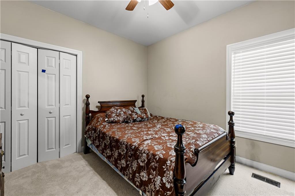 915 Magnolia Way Hampton, GA 30228 - Photo 36 of 68 a bed sitting in a bedroom next to a window and a chandelier